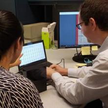 An image of ARMS Staff assisting a Researcher find records from the online archival collections