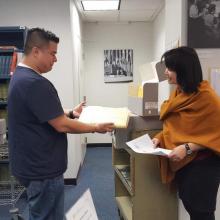 Le personnel de l'ARMS remet un document d'archives à un chercheur